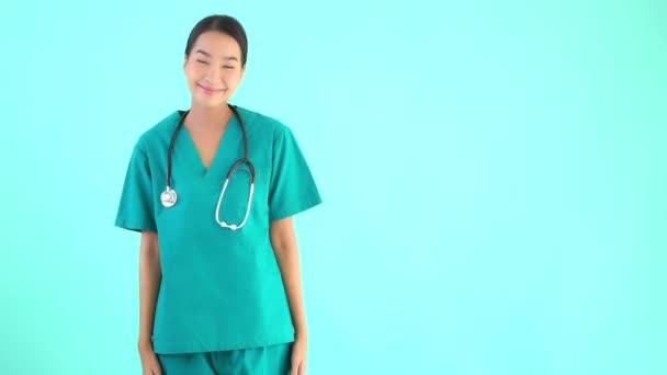 Portrait belle jeune asiatique médecin femme montrant pouces vers le haut sur fond bleu isolé
 - Séquence, vidéo