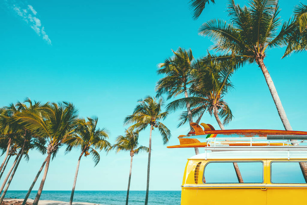 Oldtimer geparkt am tropischen Strand (am Meer) mit Surfbrett auf dem Dach - Freizeitausflug im Sommer. Retrofarbeffekt - Foto, Bild