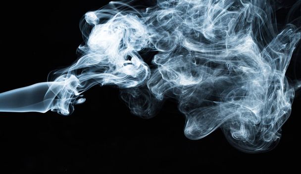 Background image of a wisp of smoke on a dark background. The texture of the flowing smoke. Frozen smoke on a dark background. Graphic resources dark backdrop. Texura of white clouds of fog. Curls of smoke frozen in motion. - Zdjęcie, obraz