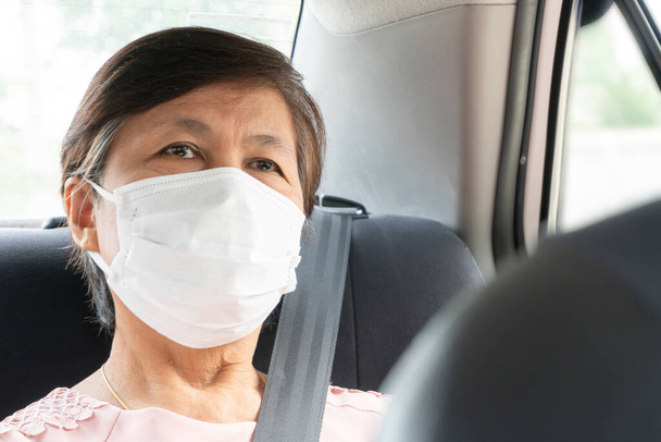 Asian elderly woman Passenger wear surgical mask for prevent coronavirus or Covid-19 while sitting in car. pandemic virus in Public transportation. Life, Health care concept. - Foto, immagini