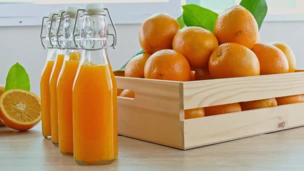stapel verse sinaasappels in houten doos en glazen sap - Video