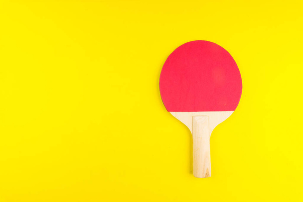 Raquette de ping-pong sur fond jaune dans un style minimal. Concept de divertissement sportif. Vue du dessus Espace de copie Modèle pour le texte ou votre conception
. - Photo, image