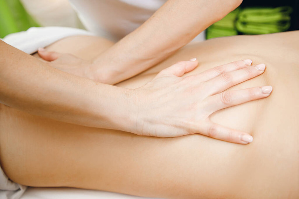 Hands of professional doctor massage therapist treats back athlete - Φωτογραφία, εικόνα