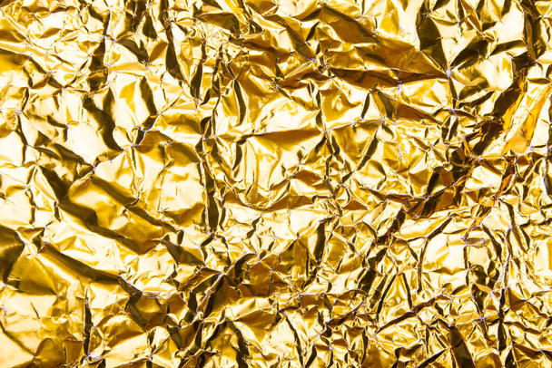 Gold zerknitterte Folie Papier Textur Hintergrund. - Foto, Bild
