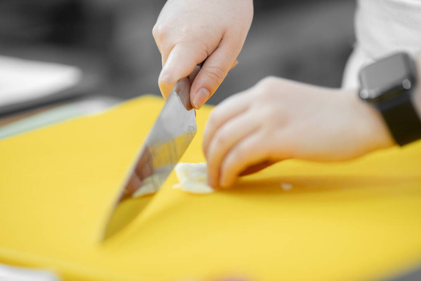 Ruce žena kuchař řez nůž s česnekem a cibulí na řezání palubě detailní - Fotografie, Obrázek