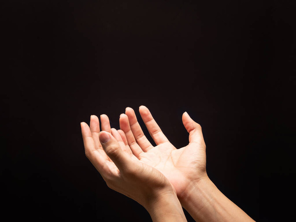 Praying hands in the dark background with faith in religion and belief in God. - Foto, Bild
