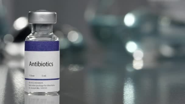Antibiotics vial in medical lab on left side slowly rotating. - Filmagem, Vídeo
