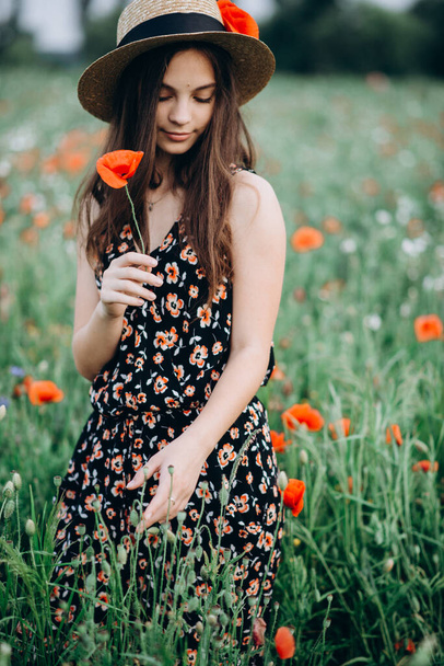 Menina livre bonita em um chapéu em um campo de verão de papoilas vermelhas. Foco seletivo suave
. - Foto, Imagem