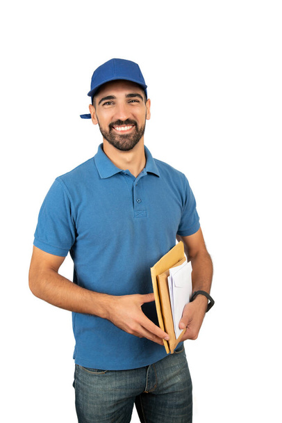Portrait of postman holding mail letters against white background. Delivery and shipping concept. - 写真・画像