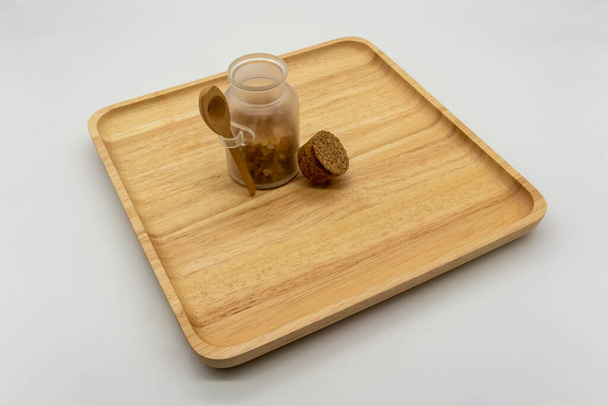 Zucchero rock in mini bottiglia di vetro carino e tappo di sughero su tagliere in legno e spazio vuoto per aggiungere isolato su sfondo bianco
. - Foto, immagini