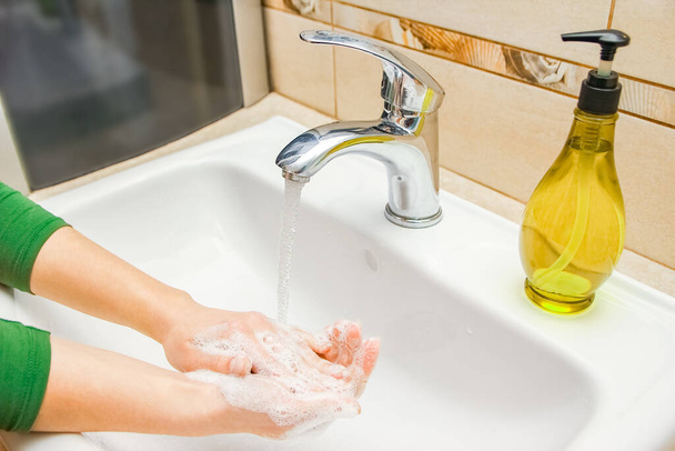Ręce z mydłem myje się pod kranem wodą. Czyste od infekcji, brudu i wirusa. W domu lub w biurze ablucji w szpitalu. - Zdjęcie, obraz