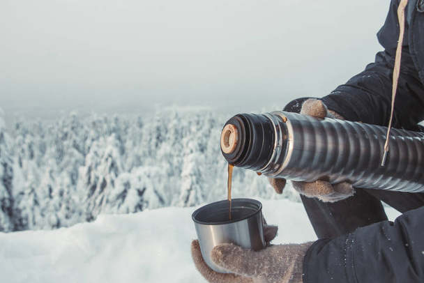 Thermos with tea in winter forest - Foto, Imagem