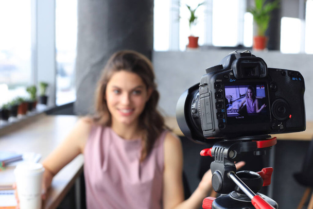 Beautiful young woman talking and smiling while making new video for her blog - Foto, immagini