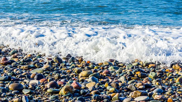 Pedras do mar e onda do mar com espuma em um dia ensolarado brilhante
 - Foto, Imagem