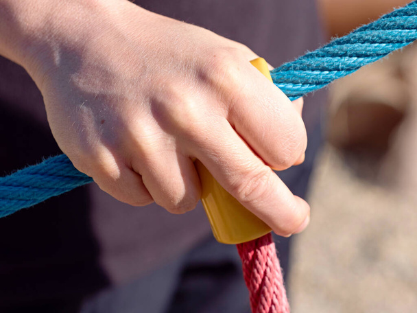 Hand holding rope while climbing wall. Entertainment and recreation, mountaineering training, sunlight effect. House, defens - Foto, Imagem