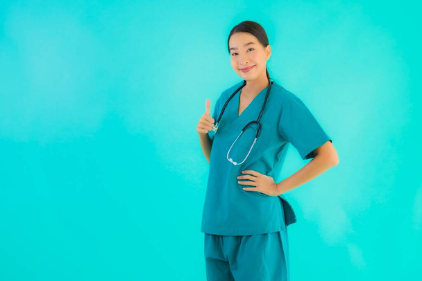 Πορτρέτο όμορφη νεαρή Ασιάτισσα γιατρός γυναίκα χαρούμενο χαμόγελο για την εργασία στο νοσοκομείο και κλινική σε μπλε απομονωμένο φόντο - Φωτογραφία, εικόνα