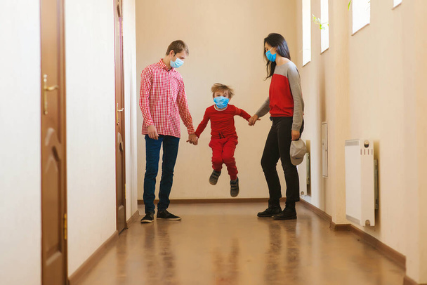Family wearing face masks. Prevention coronavirus. Stay at home. Home quarantine. Coronavirus epidemic. Parents and kid wearing a surgical masks. Coronavirus outbreak. New real life. - Photo, Image
