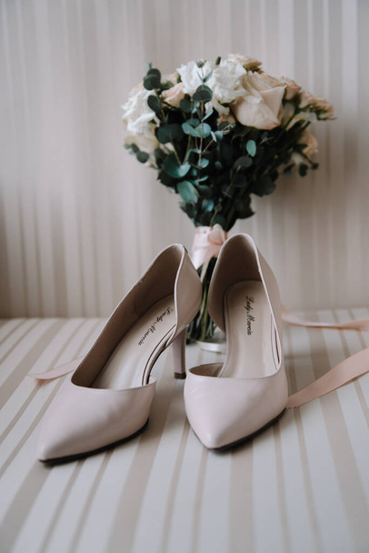 Bridal morning details composition. Top view of wedding rings, beautiful bouquet of pink flowers with ribbons, boutonniere and leather shoes. Flat lay. - Φωτογραφία, εικόνα