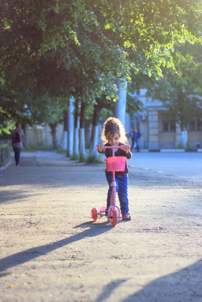 Yong κορίτσι βόλτα στο δρόμο με σκούτερ παιδί - Φωτογραφία, εικόνα