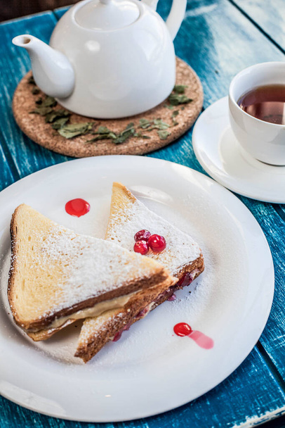 Two sweet sandwiches with black tea on the blue wooden table	 - Foto, Imagem