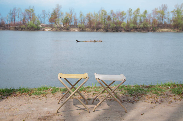 dvě malé židle stoličky na břehu řeky nikdo pro dva přátele - Fotografie, Obrázek