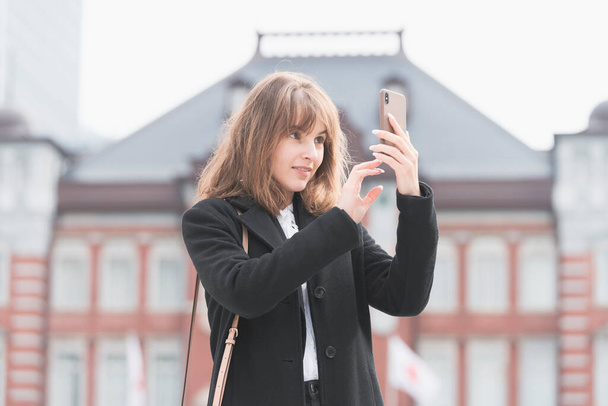 Giovane donna utilizzando smartphone e scattare foto e utilizzando applicazioni
 - Foto, immagini