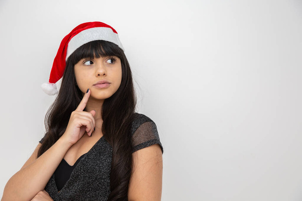 Joyeux jeune femme en bonnet Père Noël réfléchi
 - Photo, image