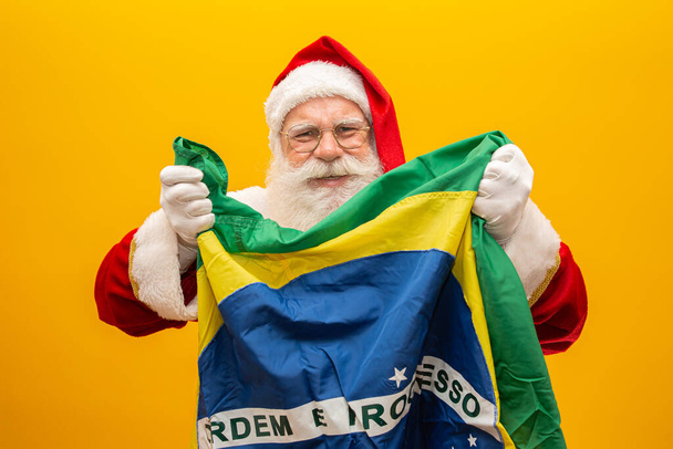 Ο Άγιος Βασίλης είναι οπαδός της Βραζιλίας. Υποστηρικτής του Αϊ Βασίλη της Βραζιλίας. Πρωτάθλημα ποδοσφαίρου. Ο Άγιος Βασίλης κρατάει τη βραζιλιάνικη σημαία. Αγώνας ποδοσφαίρου. - Φωτογραφία, εικόνα