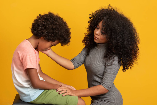 Endişeli Afrikalı Amerikalı anne, üzgün, küçük melez oğlunun elini tutarak destek veriyor ve teselli ediyor, siyah anne koruyucu aile çocuğu.. - Fotoğraf, Görsel