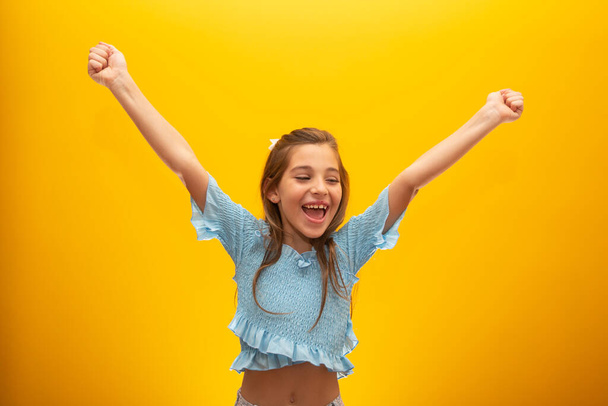 Onnellinen tyttö poseeraa nousevat kädet
 - Valokuva, kuva