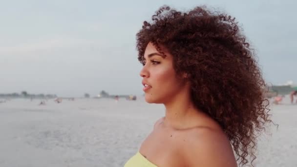 Cute curly woman having fun posing on the beach - Кадри, відео