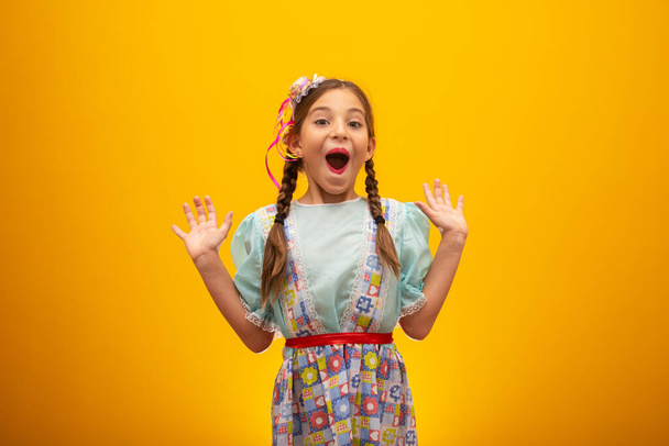 Niño en ropa típica de la famosa fiesta brasileña llamada "Festa Junina" en celebración de So Joo. Hermosa chica sobre fondo amarillo
 - Foto, imagen