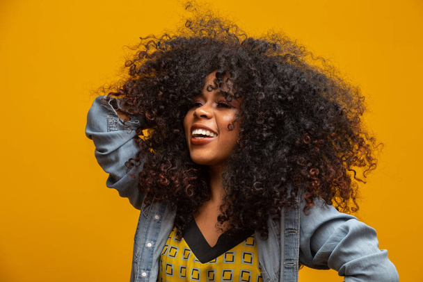 Beauty portrait of african american woman with afro hairstyle and glamour makeup. Brazilian woman. Mixed race. Curly hair. Hair style. Yellow background. - Photo, Image