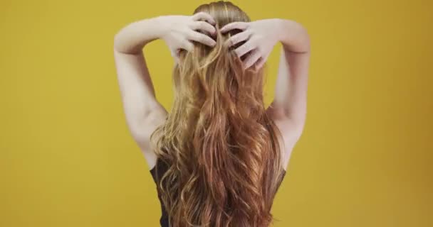 Redhead young woman posing gesturing on yellow background - Кадри, відео