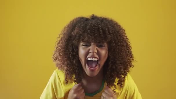 Young brazil curly woman gesturing and posing on yellow background - Materiaali, video