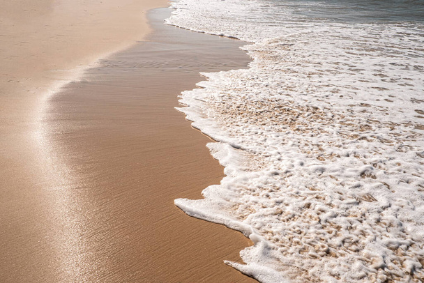 Мягкие волны с пеной океана на песчаном фоне пляжа
 - Фото, изображение