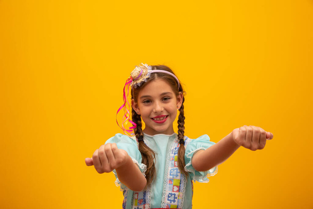 Dítě v typickém oblečení slavné brazilské strany "Festa Junina" na oslavu So Joo. Krásná dívka na žlutém pozadí - Fotografie, Obrázek