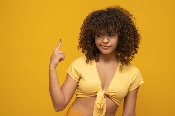 Jovem latina encaracolado mulher posando no fundo amarelo brilhante
 - Foto, Imagem