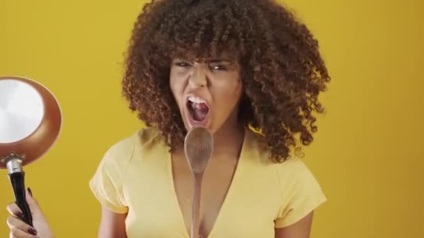 jong braziliaans krullend vrouw gebaren en poseren op gele achtergrond - Video