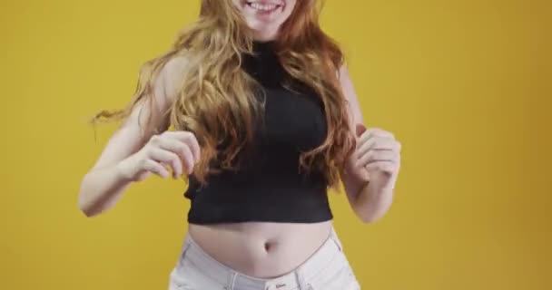 Redhead young woman posing gesturing on yellow background - Felvétel, videó