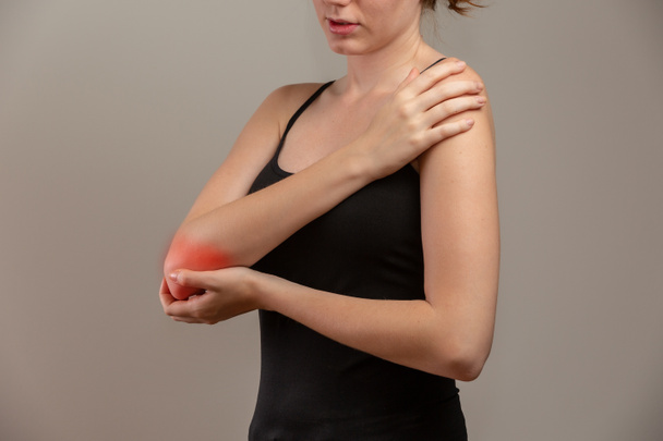Κοκκινομάλλα γυναίκα που υποφέρει από χρόνιους ρευματισμούς αρθρώσεων. Έννοια πόνου και θεραπείας αγκώνα. - Φωτογραφία, εικόνα