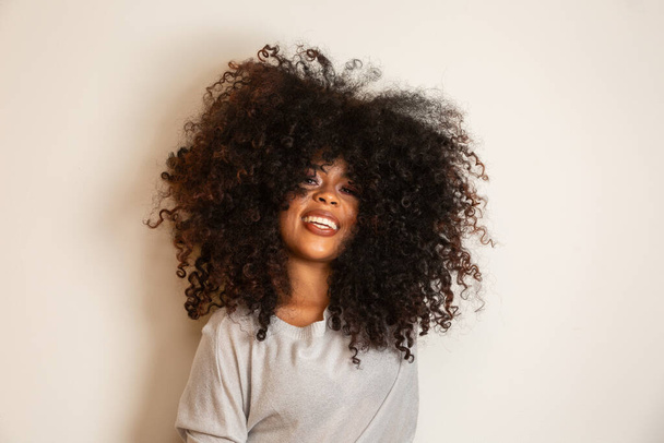 Гарний портрет афро-американки з зачіскою і гламурною гривою. Бразилька. Змішана раса. Кучеряве волосся. Стиль волосся. Біле тло. - Фото, зображення