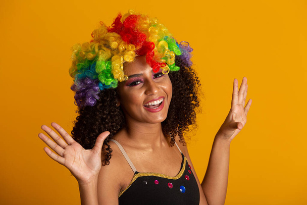 Hermosa mujer vestida para la noche de carnaval. Mujer sonriente lista para disfrutar del carnaval con una peluca colorida
. - Foto, imagen