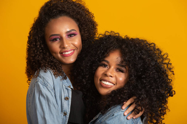 Two beautiful afro friends hugged, concept of best friends and sisters. - Photo, Image