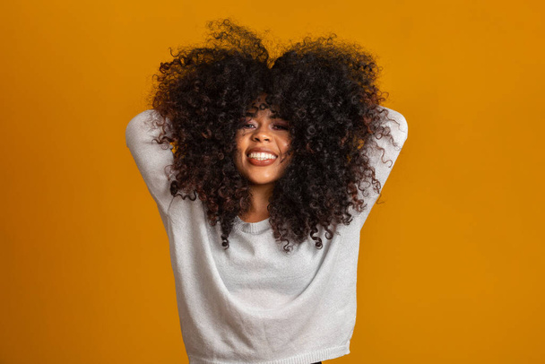 Portrait de beauté de femme afro-américaine avec coiffure afro et maquillage glamour. Une Brésilienne. Mixte. Cheveux bouclés. Coiffure. Fond jaune
. - Photo, image