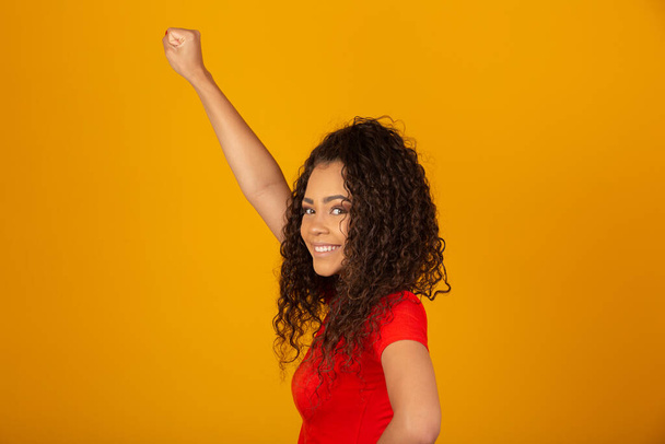 Bella giovane donna afroamericana felice ed eccitata che celebra la vittoria esprimendo grande successo, potenza, energia ed emozioni positive. Celebra il nuovo lavoro gioioso
. - Foto, immagini