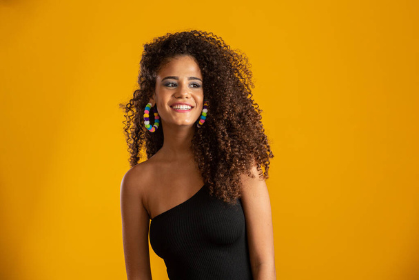 Beautiful african american girl with an afro hairstyle smiling. Beauty portrait of african american woman with afro hairstyle and glamour makeup. Brazilian young woman. - Photo, Image