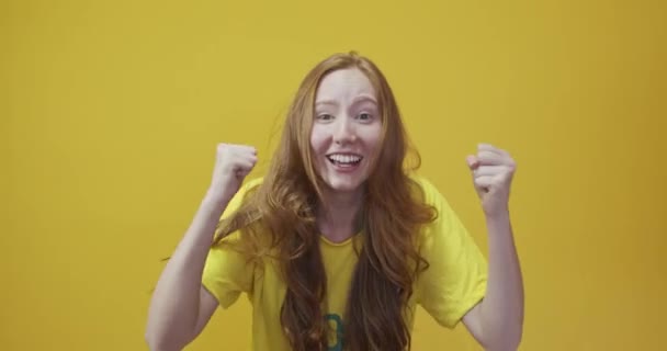 Rotschopf junge Frau posiert gestikulierend auf gelbem Hintergrund - Filmmaterial, Video