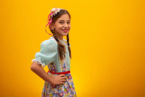 Niño en ropa típica de la famosa fiesta brasileña llamada "Festa Junina" en celebración de So Joo. Hermosa chica sobre fondo amarillo
 - Foto, Imagen