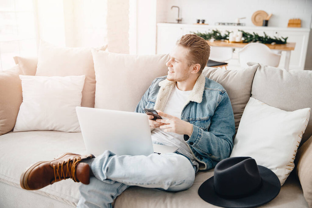 Happy young businessman using laptop at home in living room. Concept freelance dreams startup, personal growth development - Photo, Image